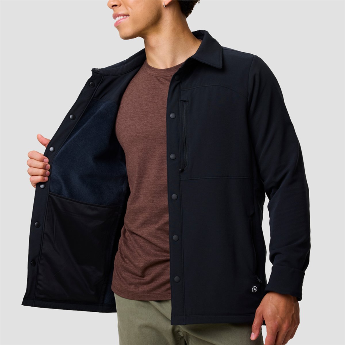 Men's black button-up shirt jacket with collar displayed over a burgundy t-shirt and khaki pants.