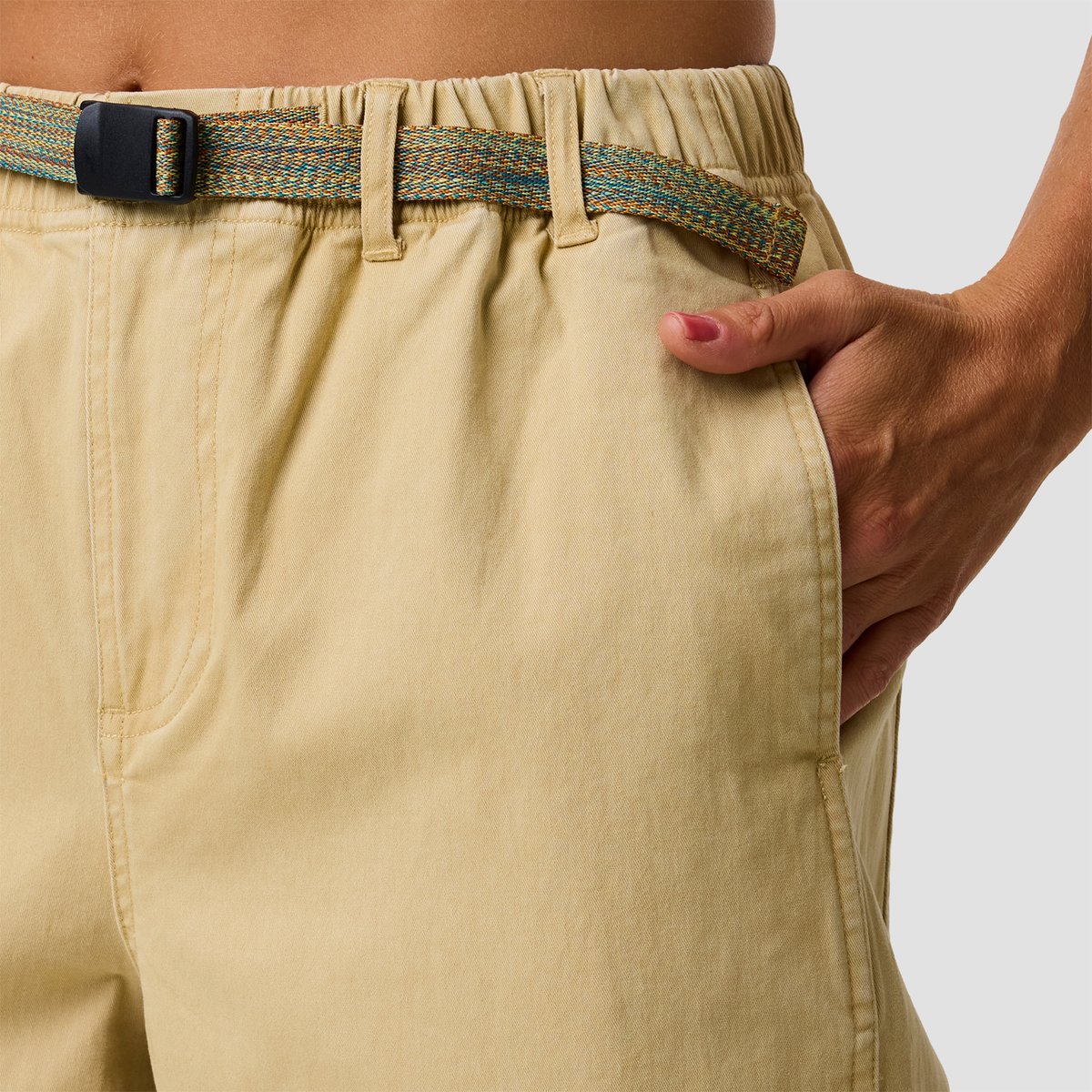 A woman wears the BGA Venture Daily pant, which has a multicolored woven belt featuring black buckle closure.