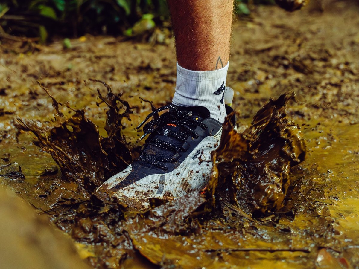 A shoe splashes in muddy water.