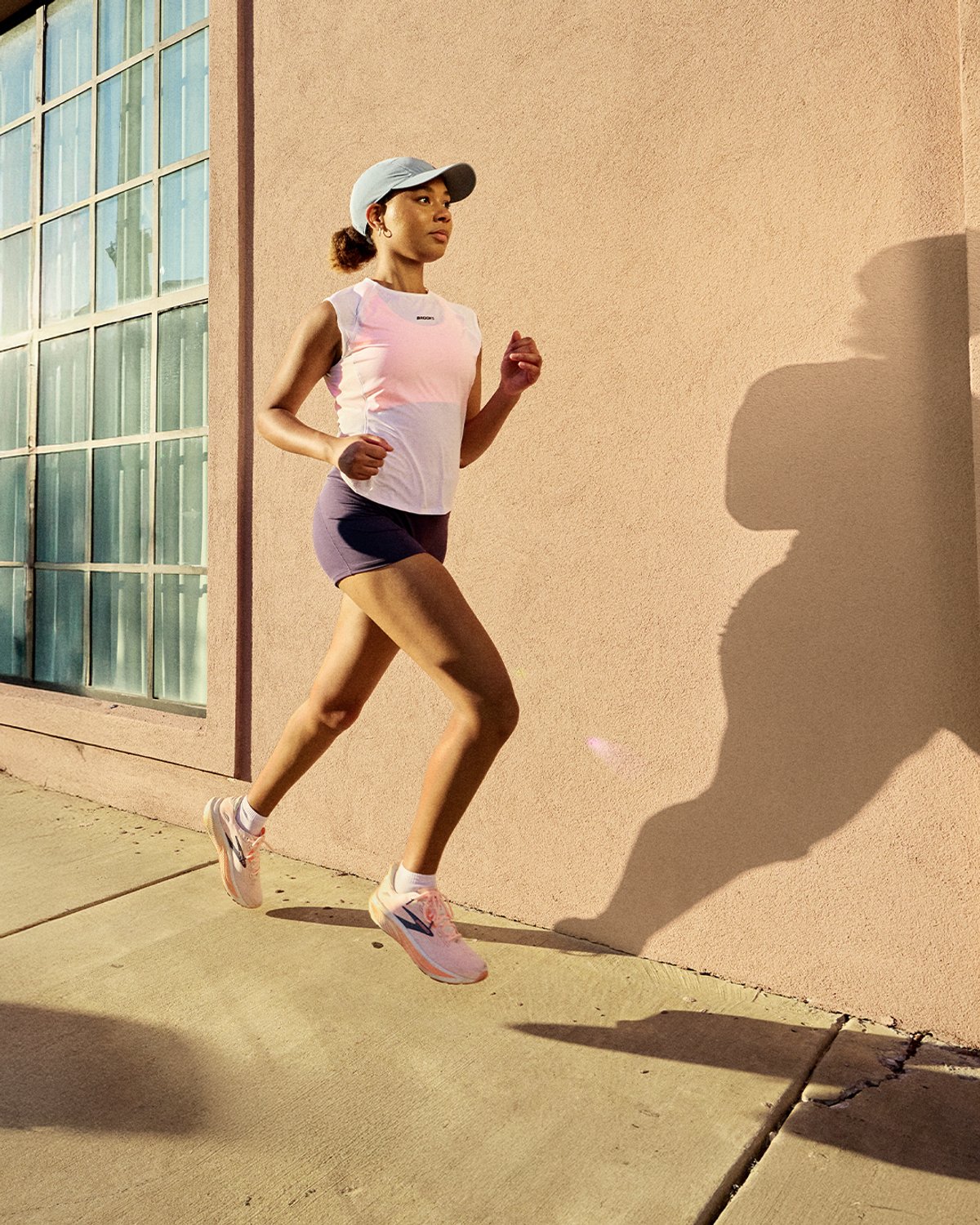Female running down a sunny sidewalk wearing Brooks Ghost 18 runnning shoe