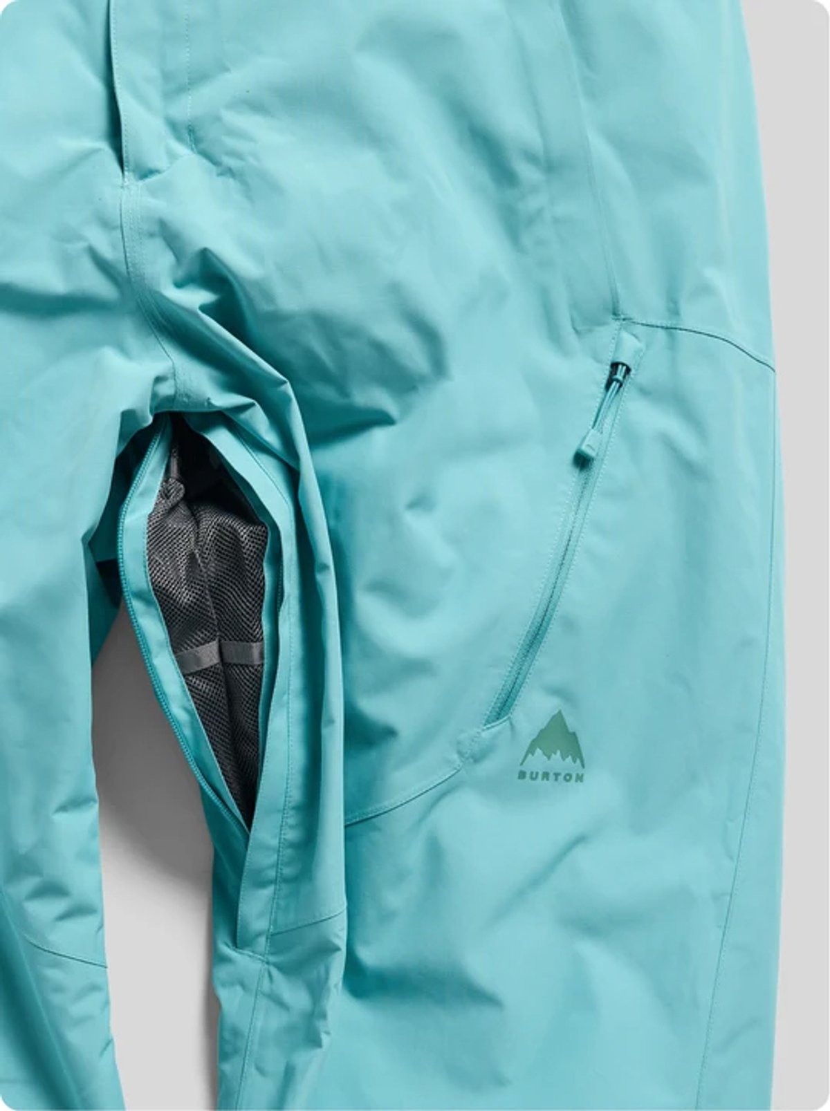 Light blue Burton ski jacket with ventilation mesh pocket and side zipper detail displayed on white background.
