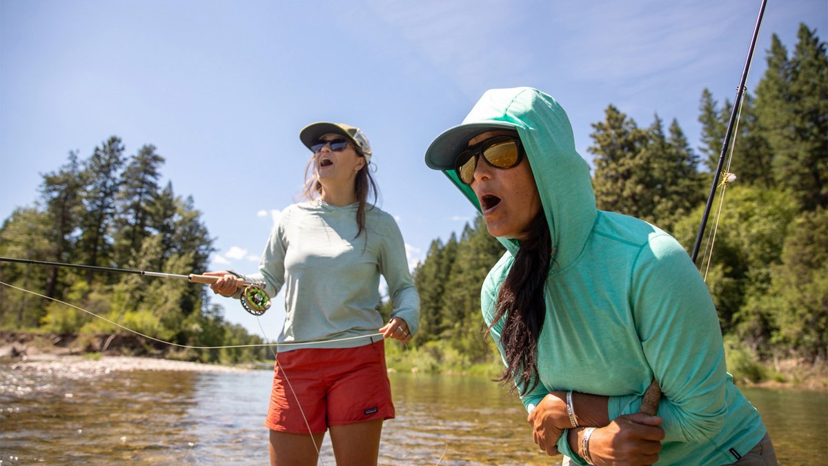 Two women fish in a river, wearing Patagonia Baggies.