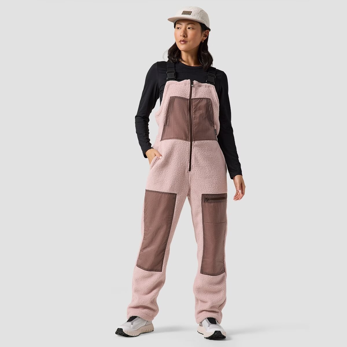 A woman wears the BGA Wander Pile Fleece Overall