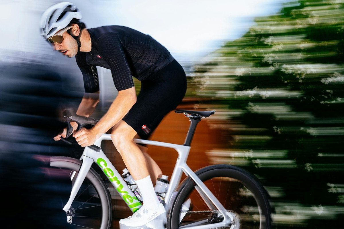 Road cyclist wearing Castelli cycling jersey, bib shorts, road helmet, and Nimbl shoes riding Cervélo Soloist road bike at speed