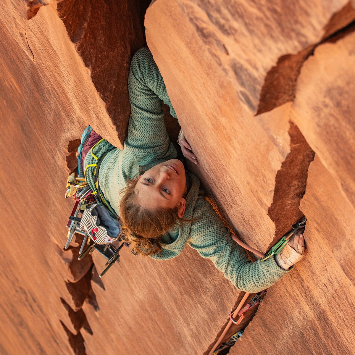 A woman pulls off her blue Patagonia puffy.
