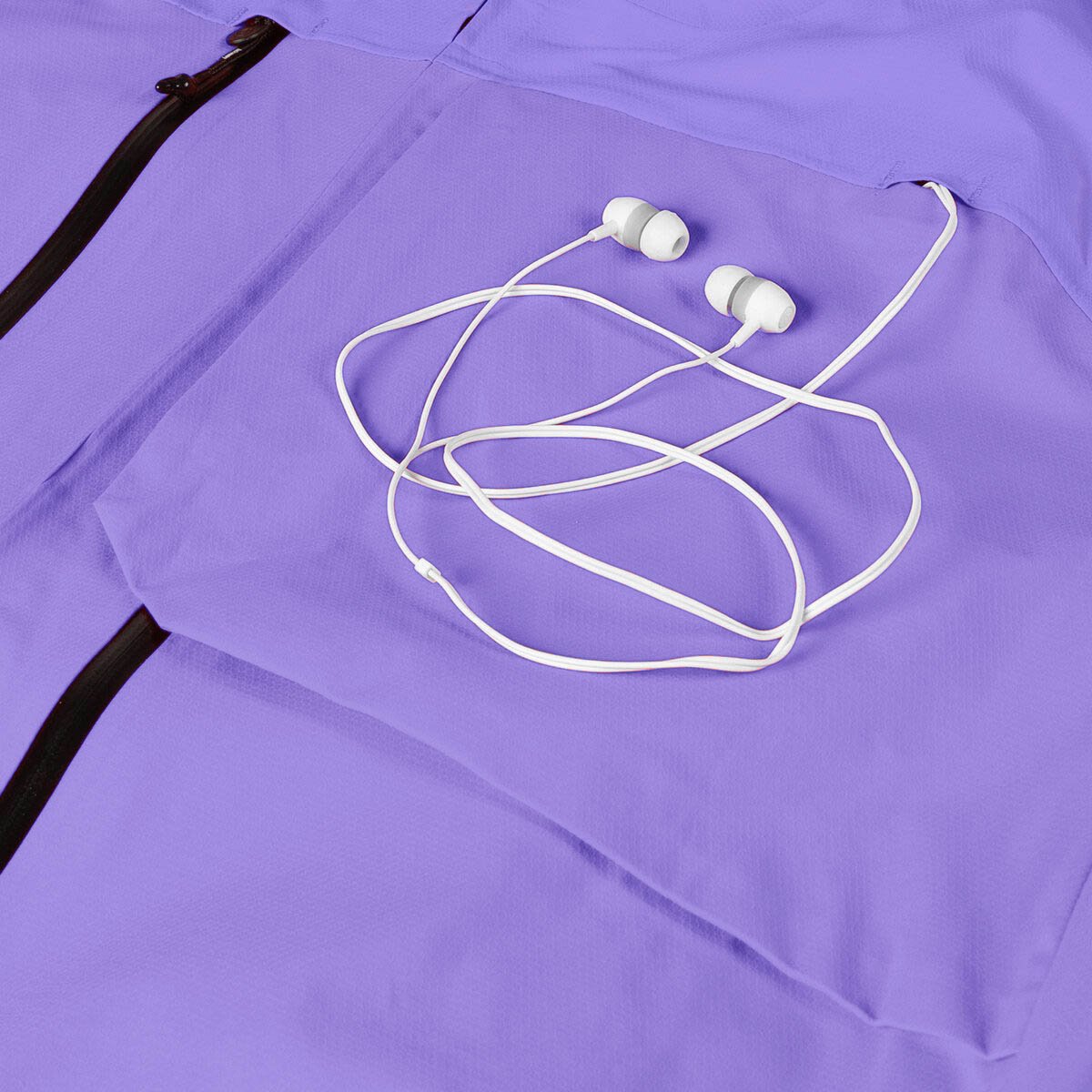 Jacket with white headphone cords threaded out through chest pocket slot.