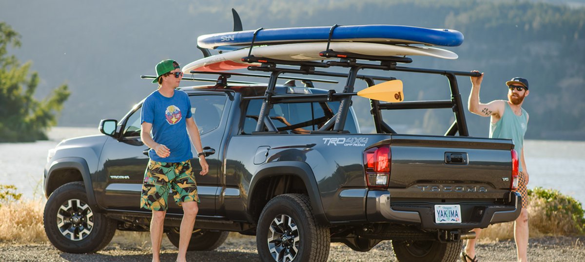 Pickup truck with roof rack loaded with surfboards and paddleboards for a day on the water