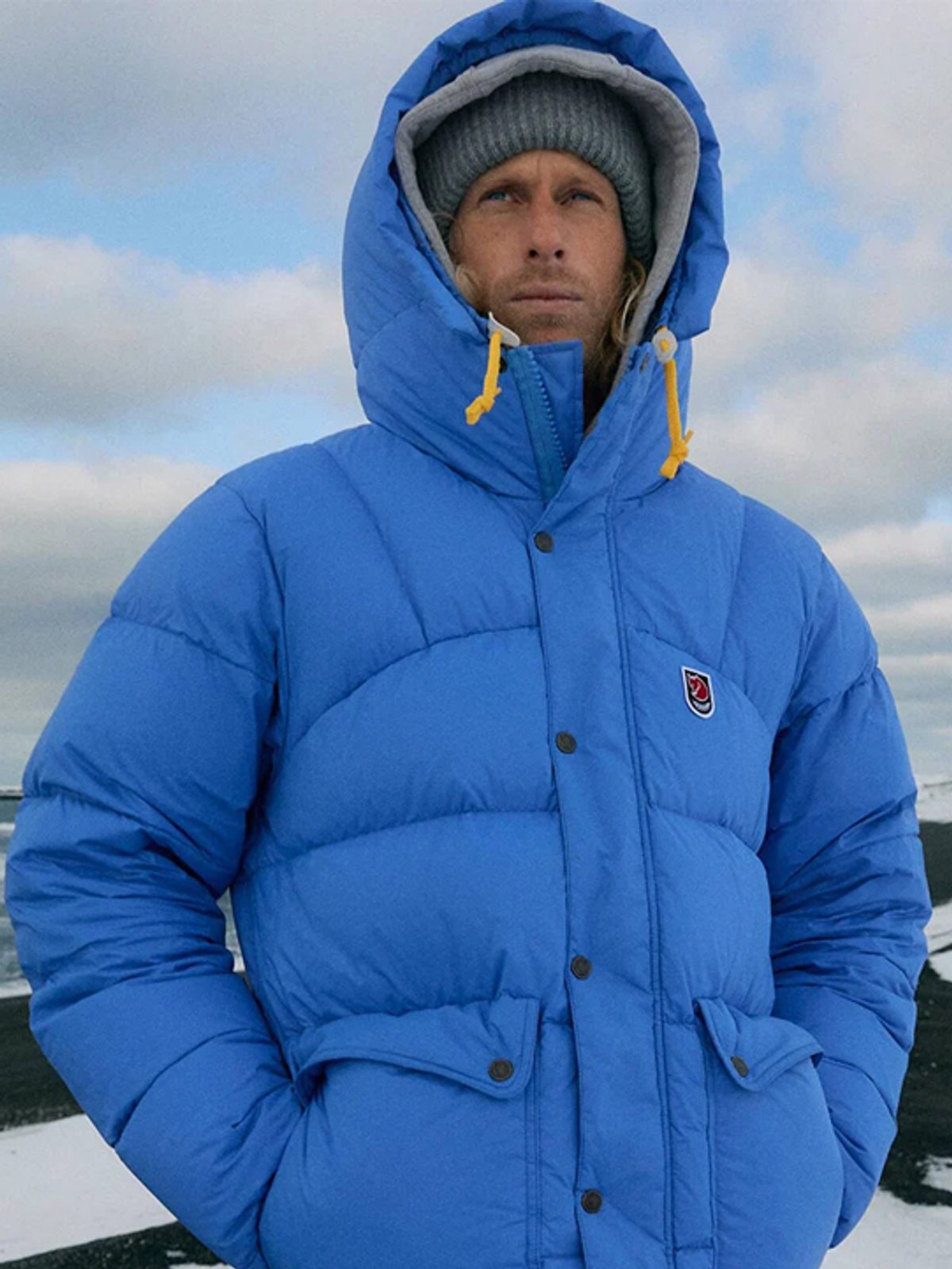 A man wears the Down Lite Jacket against a snowy landscape.