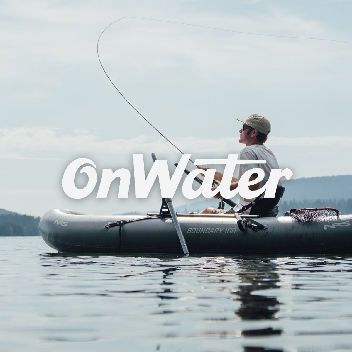 An angler fly fishing from an inflatable kayak on a calm lake, rod bent mid-cast, net resting nearby. Featuring the onWater logo. 