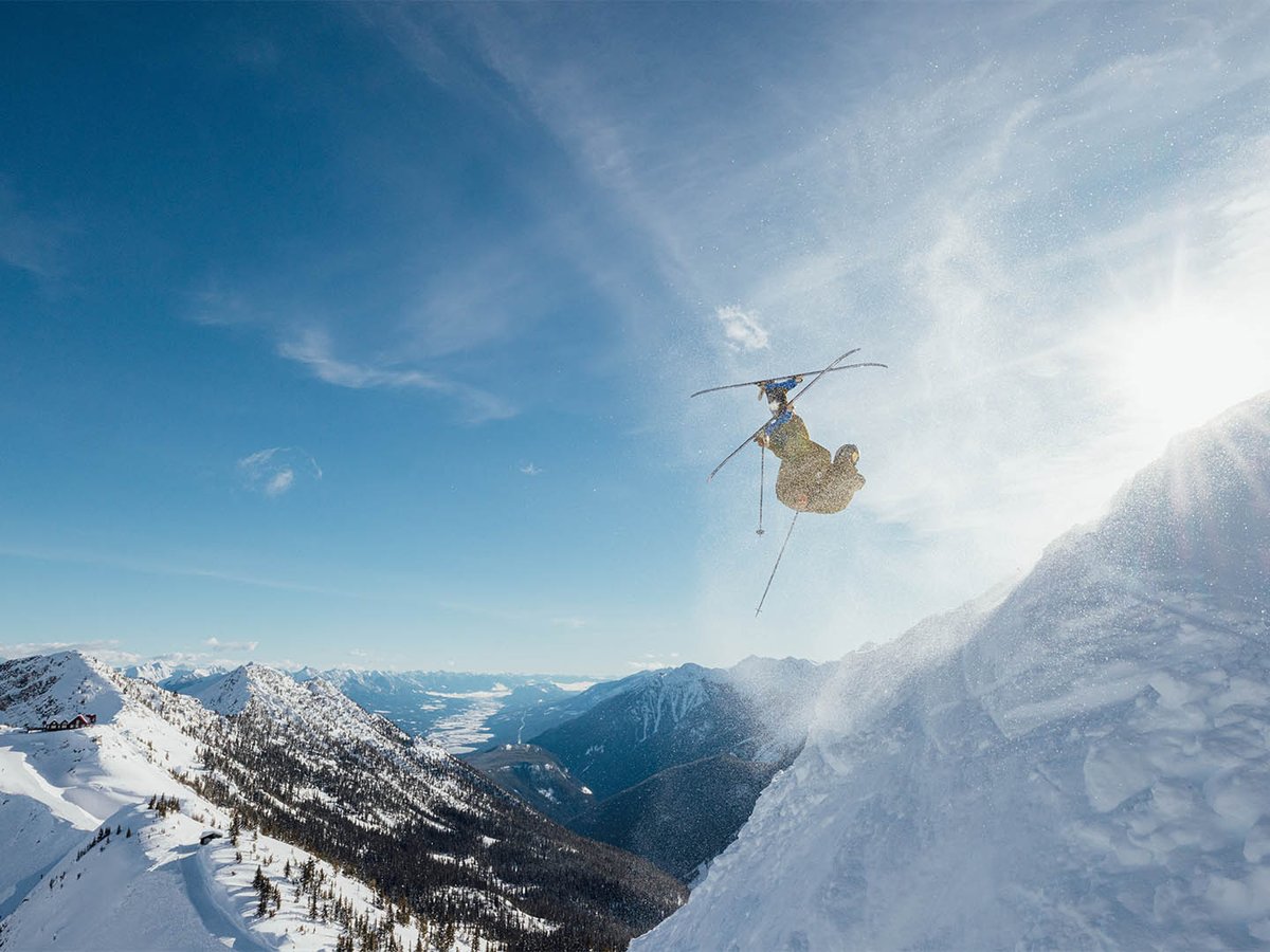 Skier throwing a trick after launching off a drop.