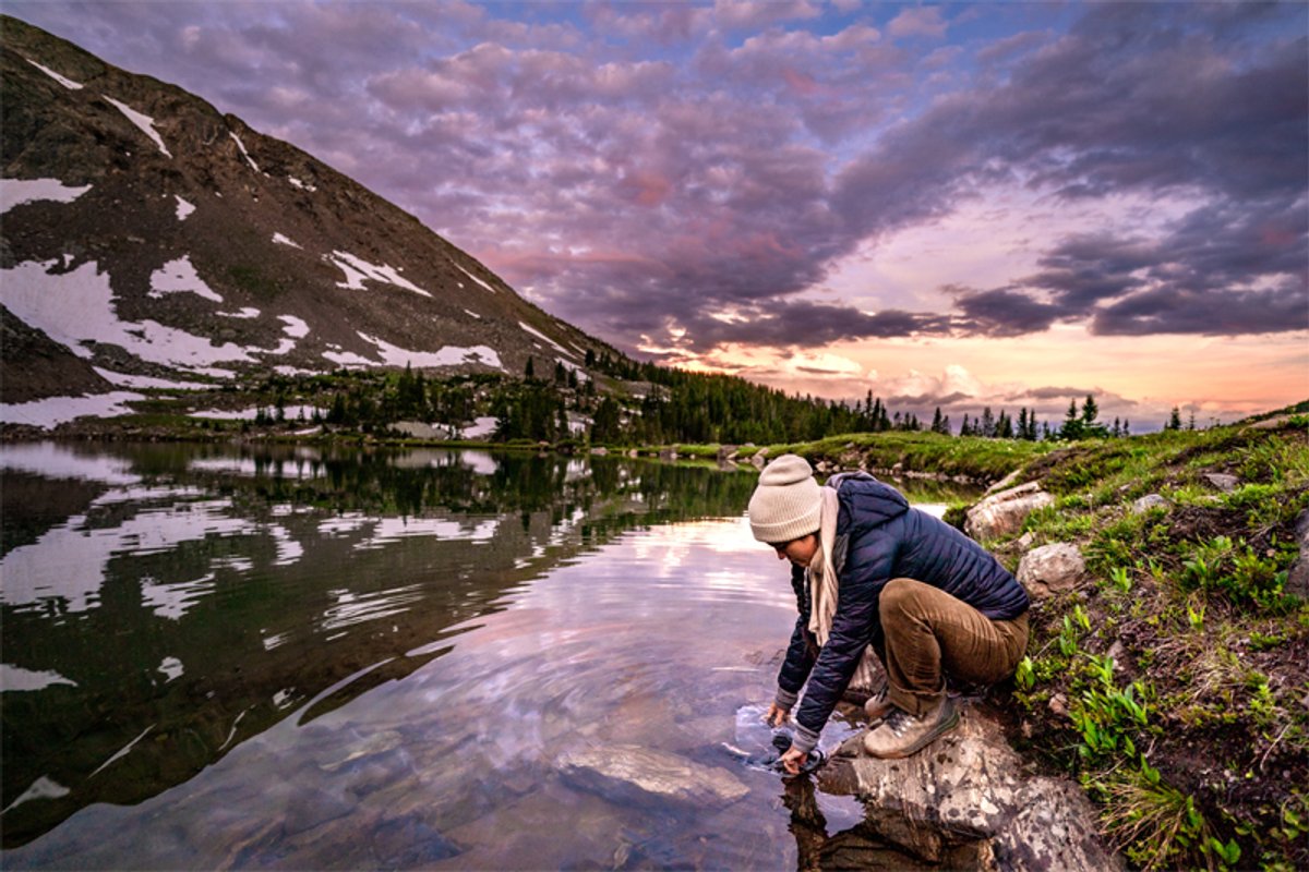 A woman fills up the Platypus GravityWorks reservoir in a river.
